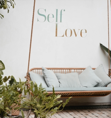 outdoor swing with self-love written on the wall | Financial Therapy Solutions with Wendy Wright