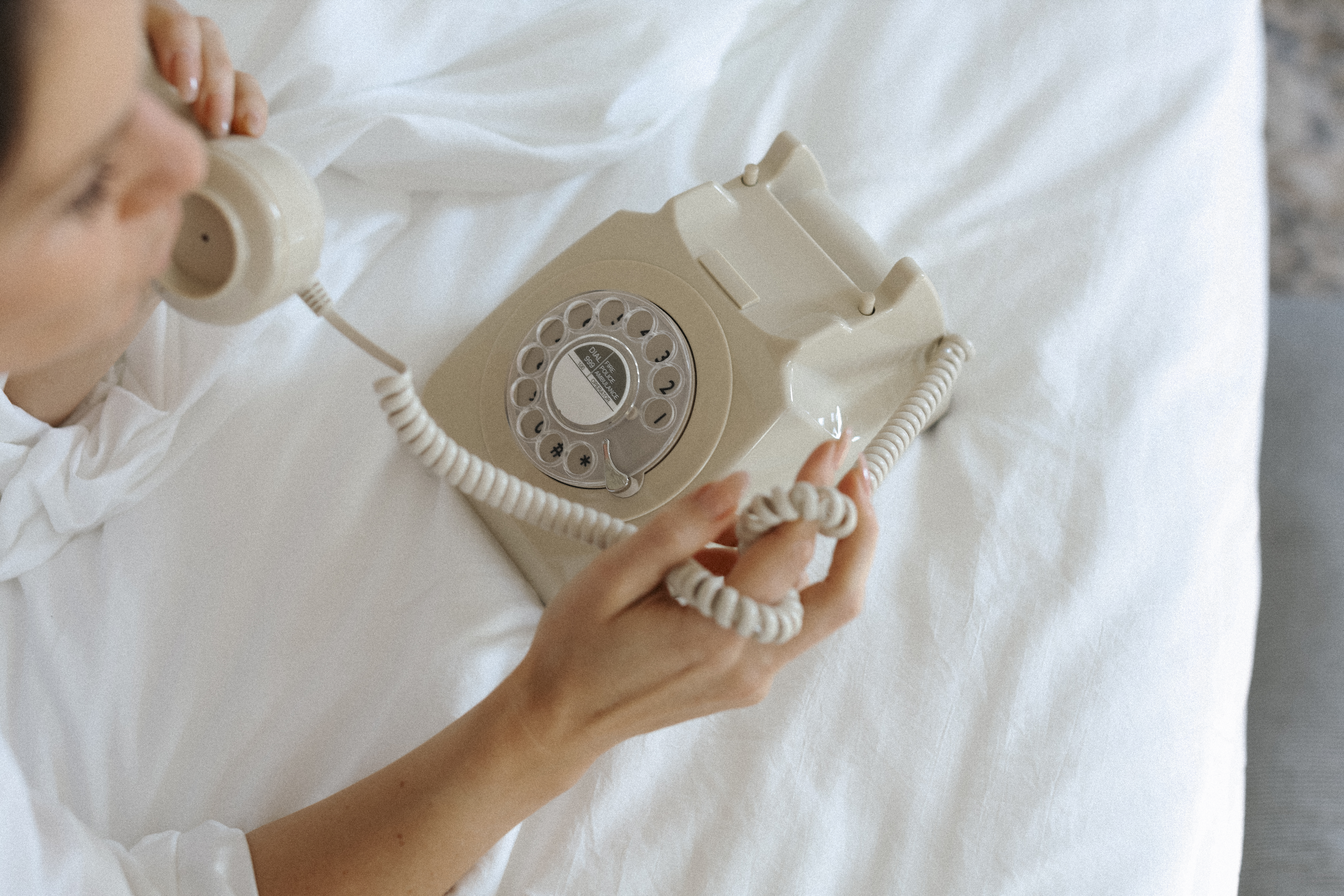 woman on a white phone | financialtherapysolutions.com