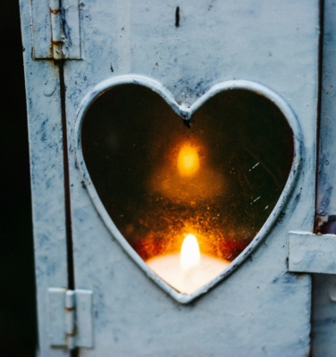 a heart-shaped window with a candle inside | financialtherapysolutions.com