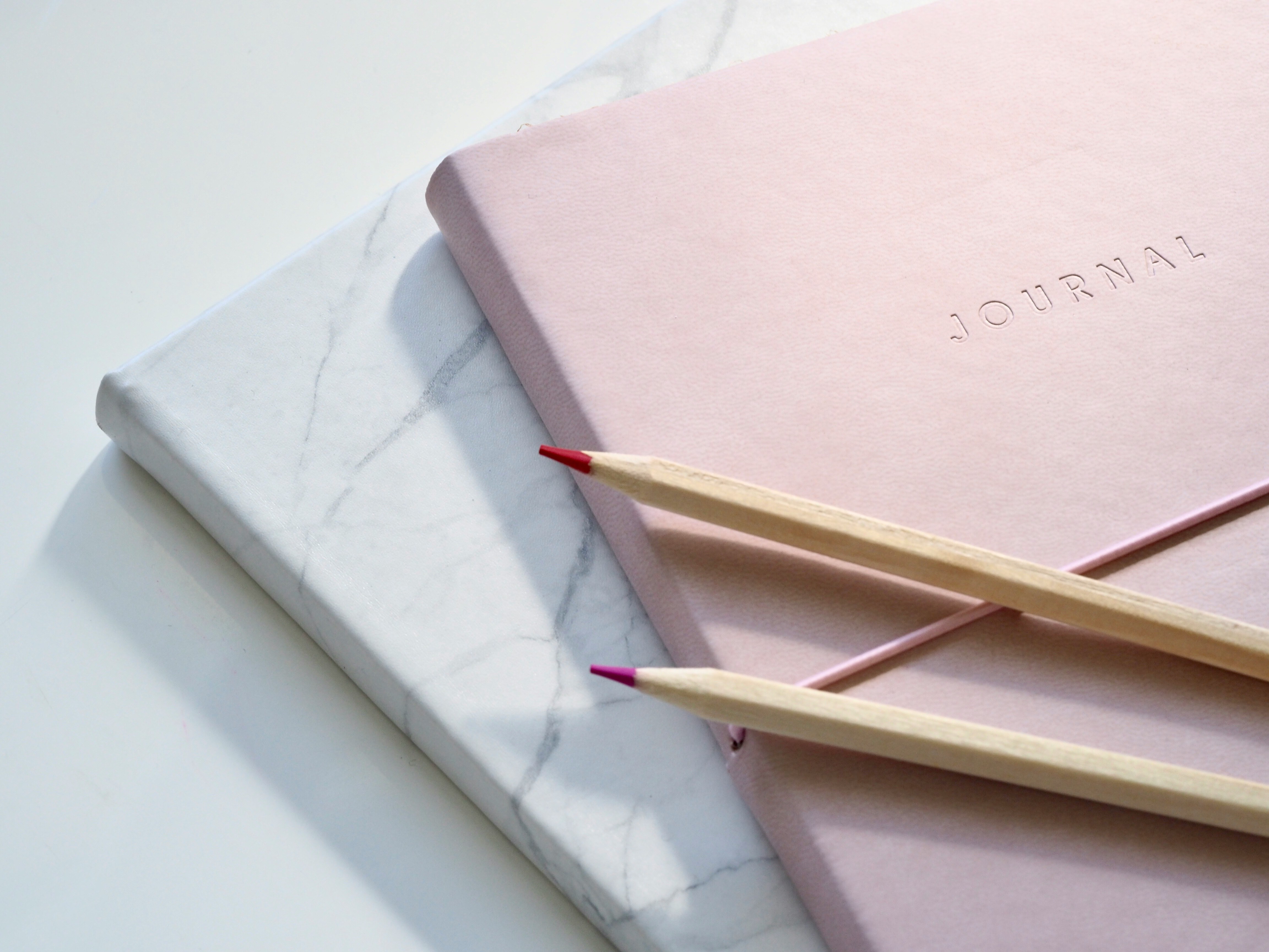 pink journal and colored pencils | financialtherapysolutions.com